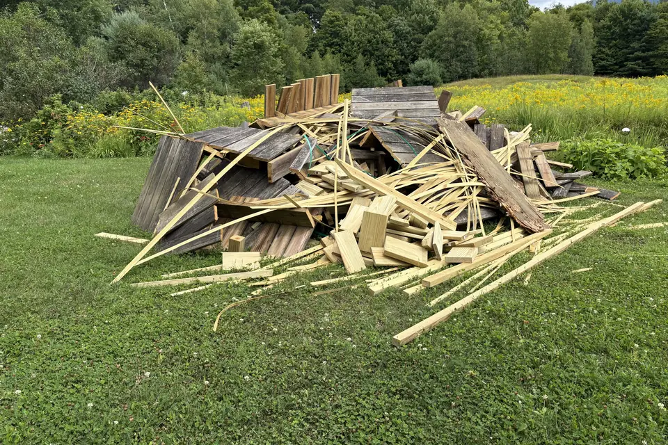 Before: Pile of torn-out deck boards on a lawn