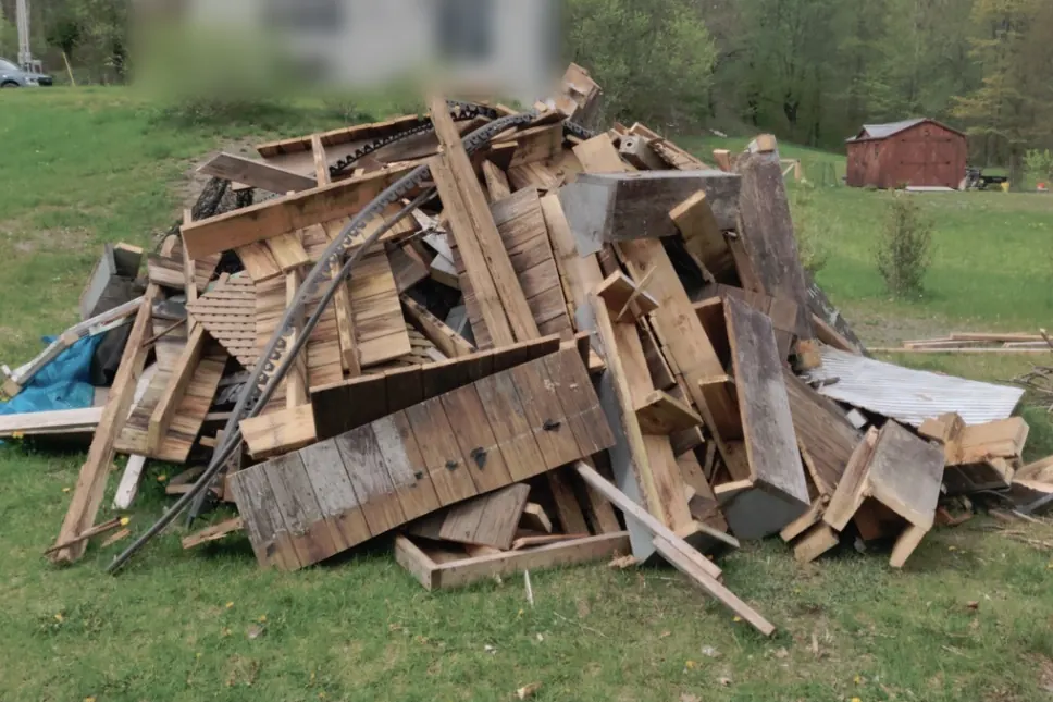 Before: Large pile of old lumber and debris in a field