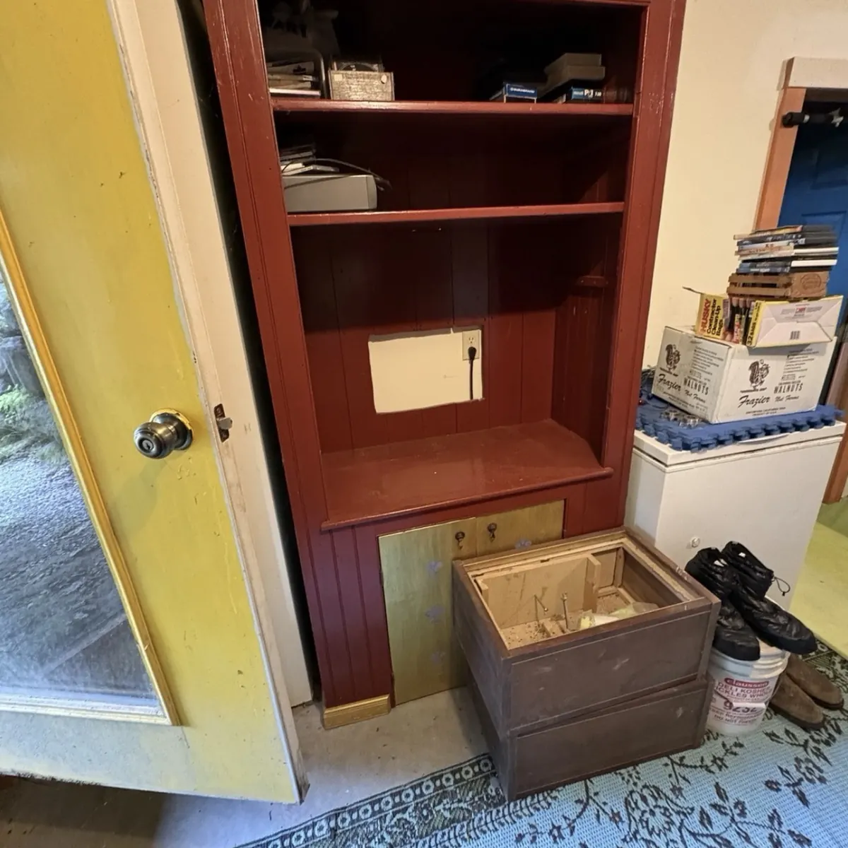 Before: Red built-in shelving unit next to a yellow door